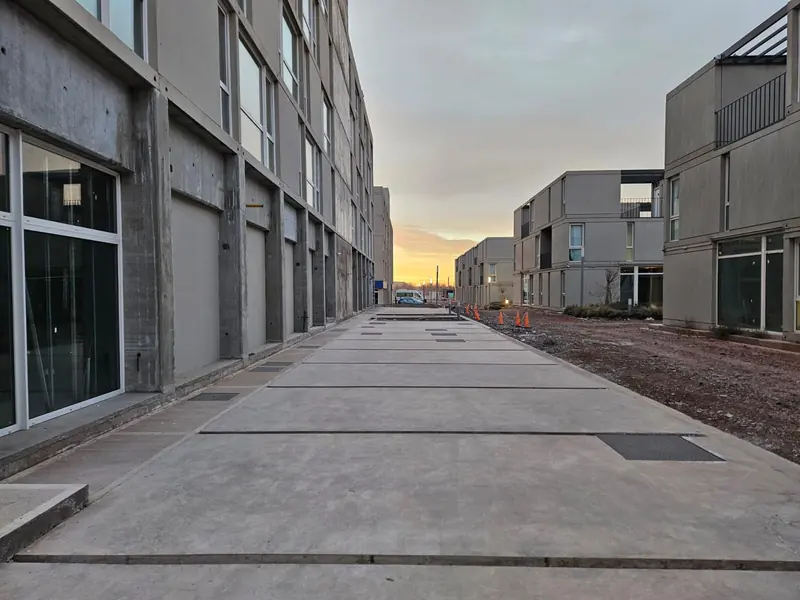 Finished concrete sidewalks between the residential blocks of the complex at dusk