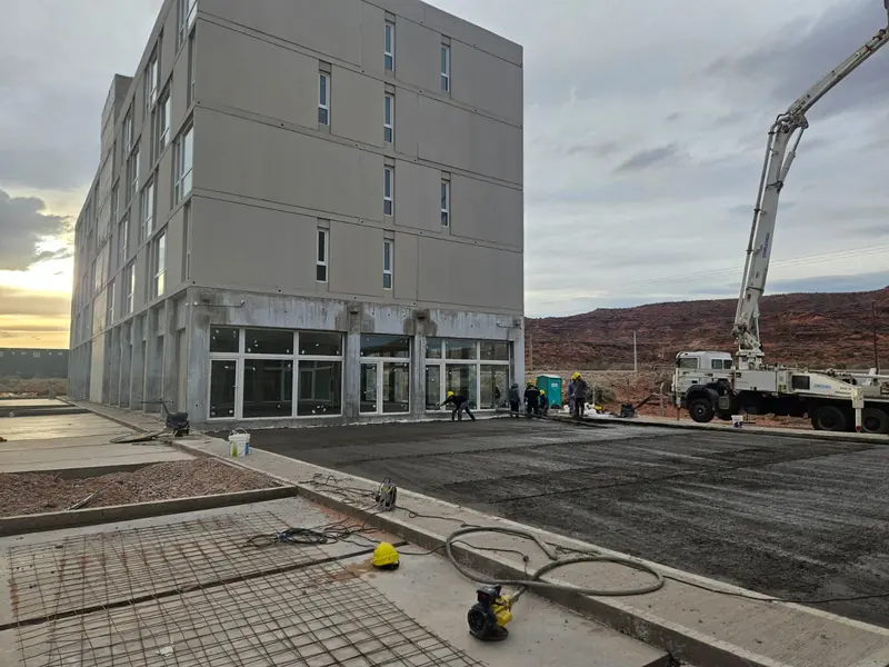 Five-storey building with new asphalt paving and a concrete pump at work