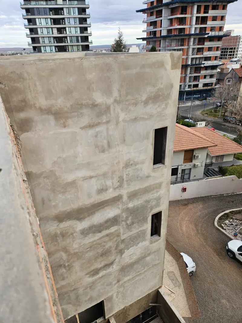 Muro medianero de hormigón visto del edificio escolar tomado desde el nivel superior
