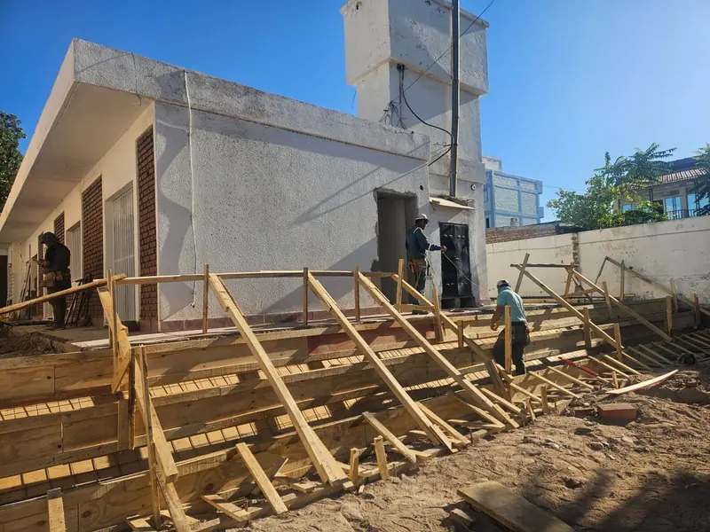 Encofrado de madera de la escalinata exterior con operarios trabajando en obra