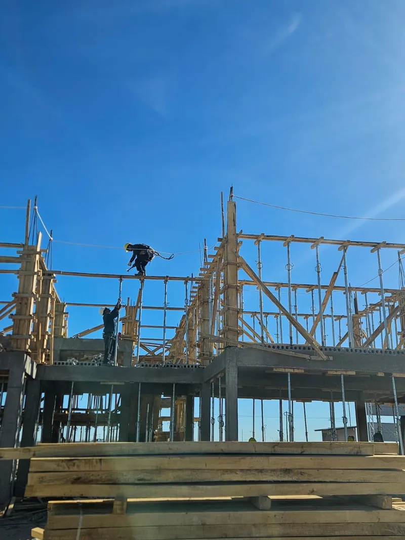 Estructura metalica de una garita en montaje, con operario trabajando arriba