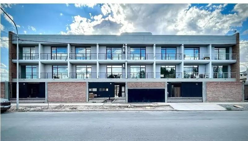 Completed facade of the two-storey duplexes with balconies, brick plinth and garages