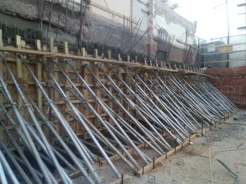 Party wall underpinning with raking steel props against the neighbouring wall