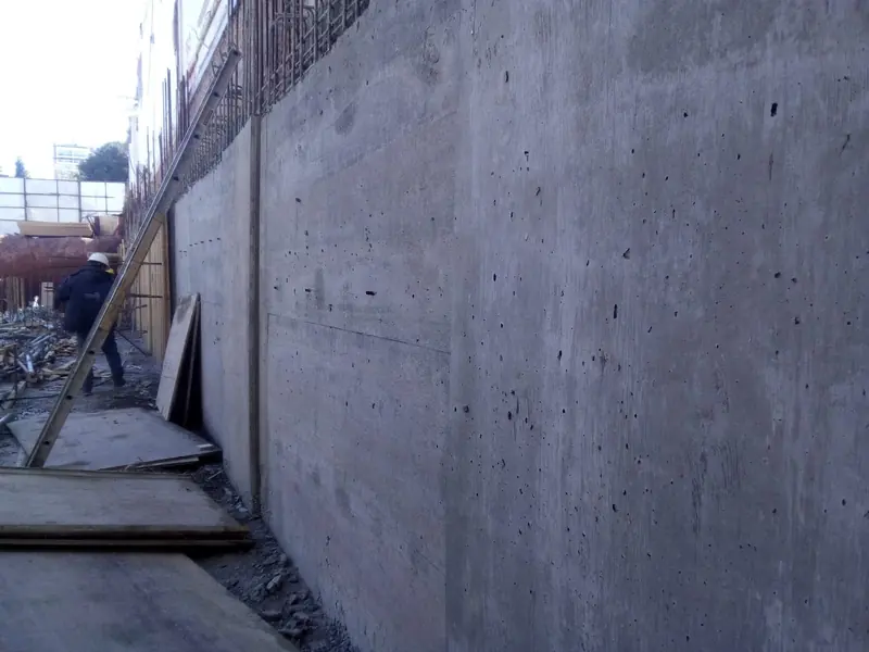 Fair-faced concrete shear wall just struck, with starter bars at the edge