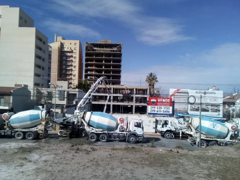 Concrete mixer trucks and pump feeding the pour on the high-rise building
