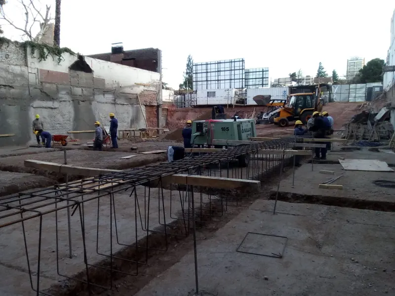 Ground beam reinforcement being fixed with a backhoe working at the rear of the site