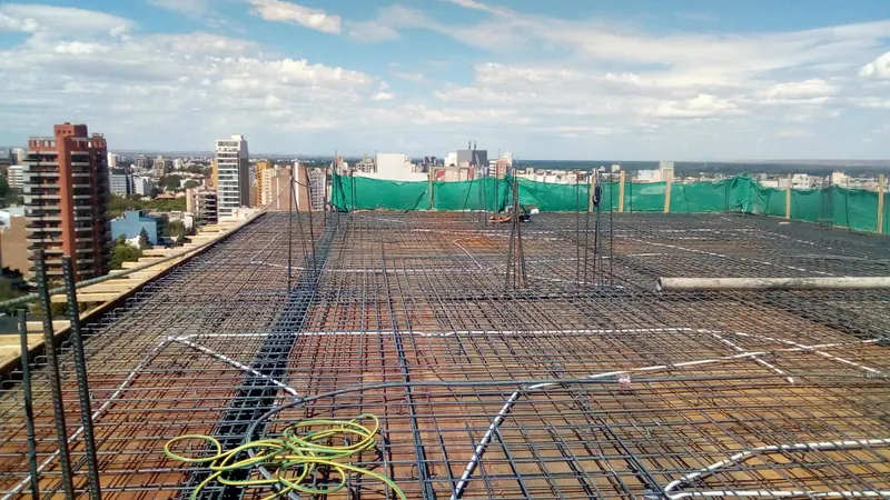 Top slab reinforced with perimeter safety netting and a panoramic view of the city