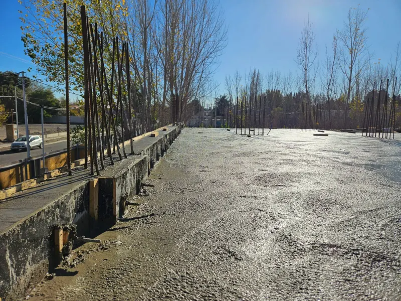 Newly poured concrete slab with starter bars around the site perimeter