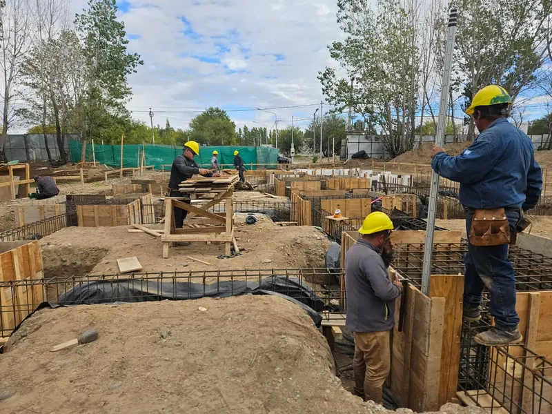 Workers in hard hats assembling formwork and reinforcement for pad footings