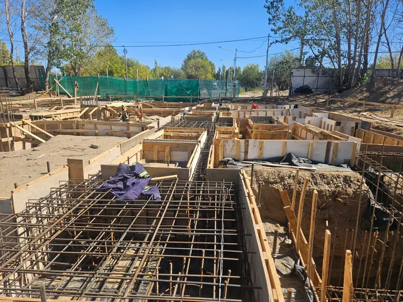 Ground beams formed and reinforced during the early stage of the works