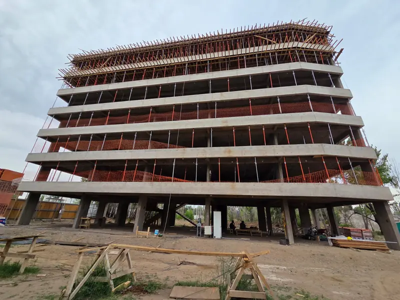 Front of the building under construction with concrete slabs and formwork above