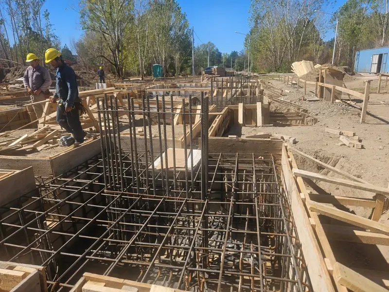 Workers assembling formwork and reinforcement for a ground beam