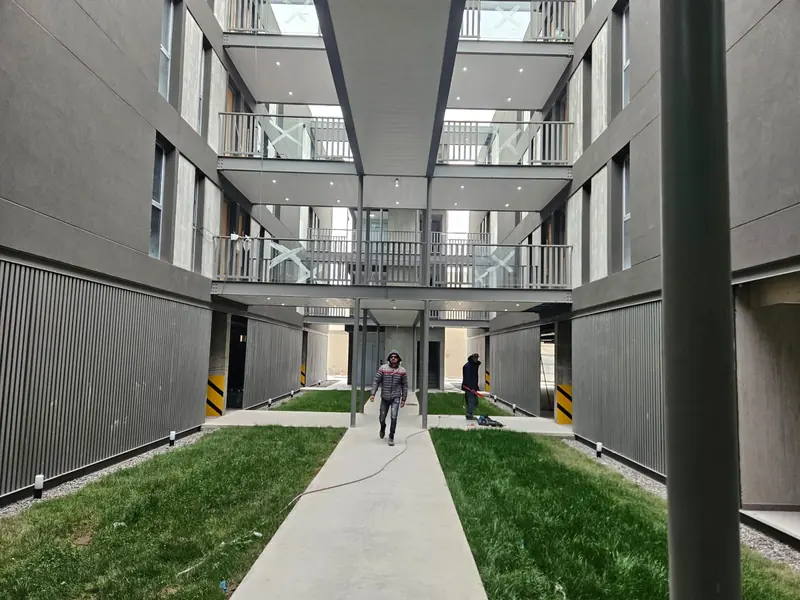 Finished internal courtyard with walkways, metal railings and a concrete path