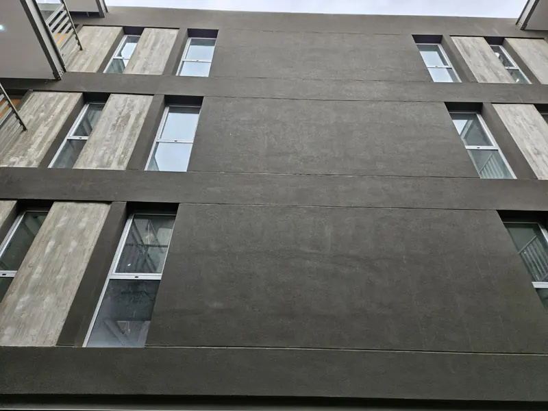 Facade detail with textured render and timber-effect finishing panels