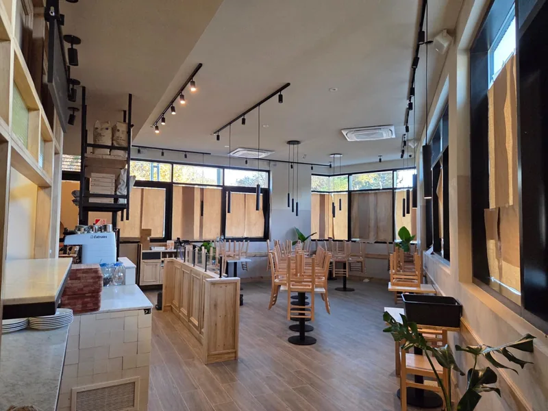 Vista del salon con la barra y las mesas de madera al fondo