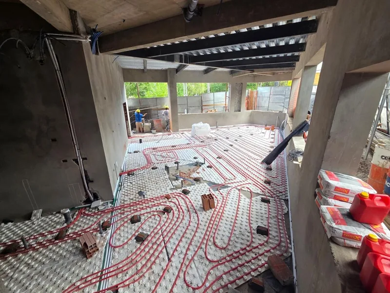 Piso radiante junto a una columna de hormigon en obra