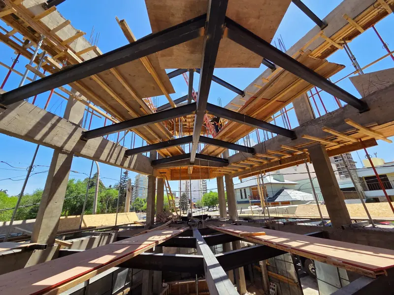 View from below of the steel beam grid and the timber formwork of the level above
