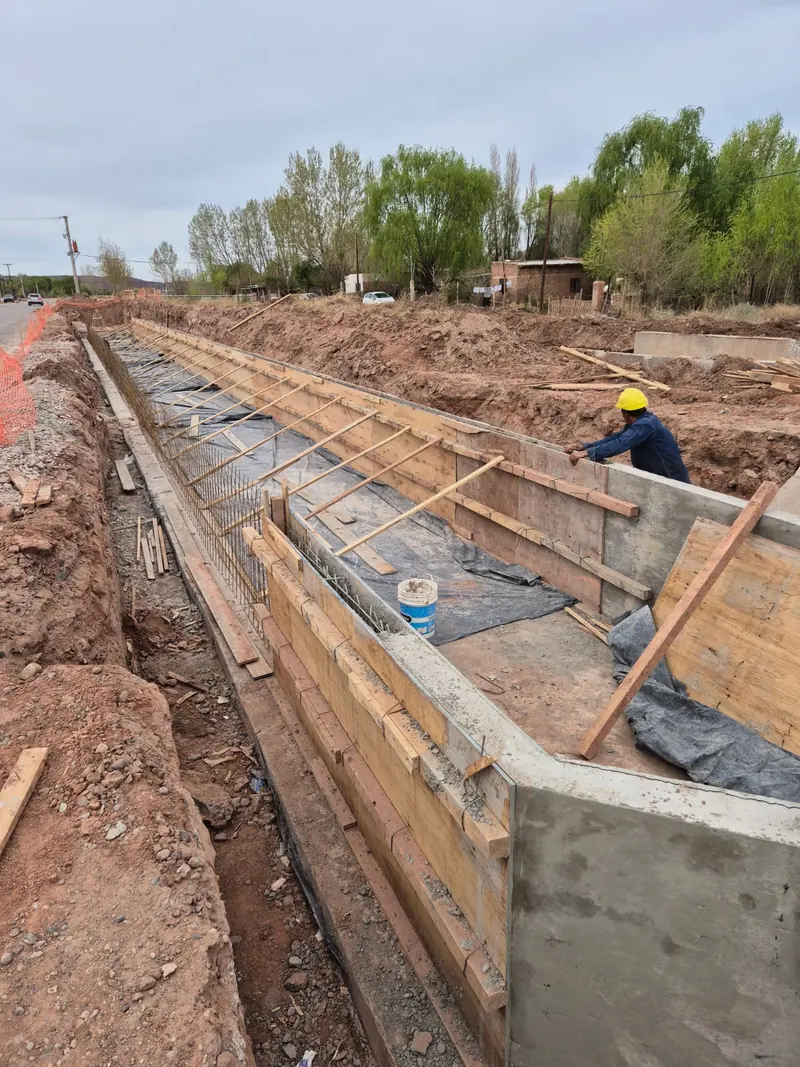 Timber formwork to the concrete channel with a worker fitting props