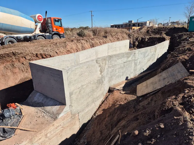 Finished concrete wall after striking formwork, beside the concrete mixer truck