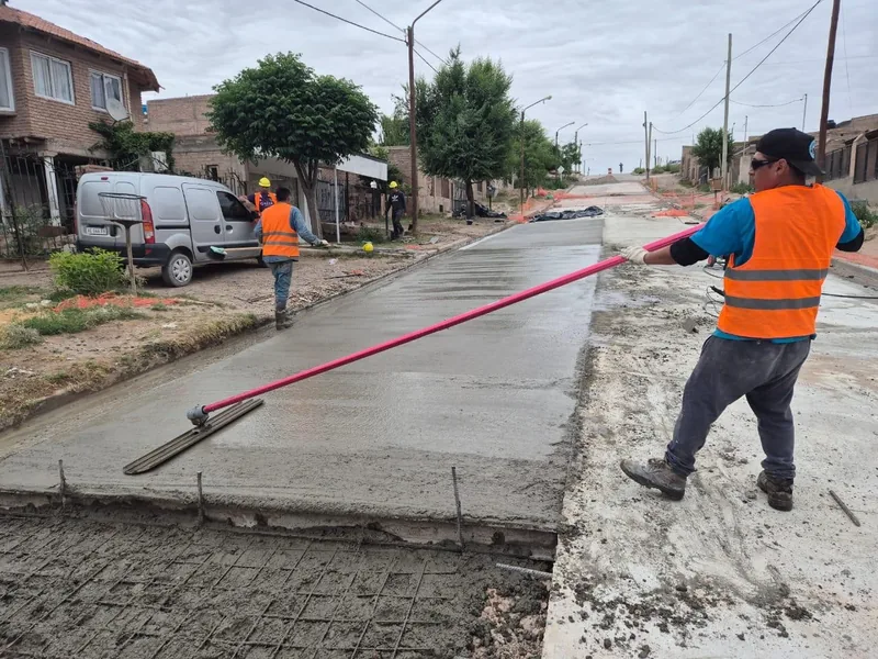 Operario terminando a mano un cordon cuneta de hormigon recien colado