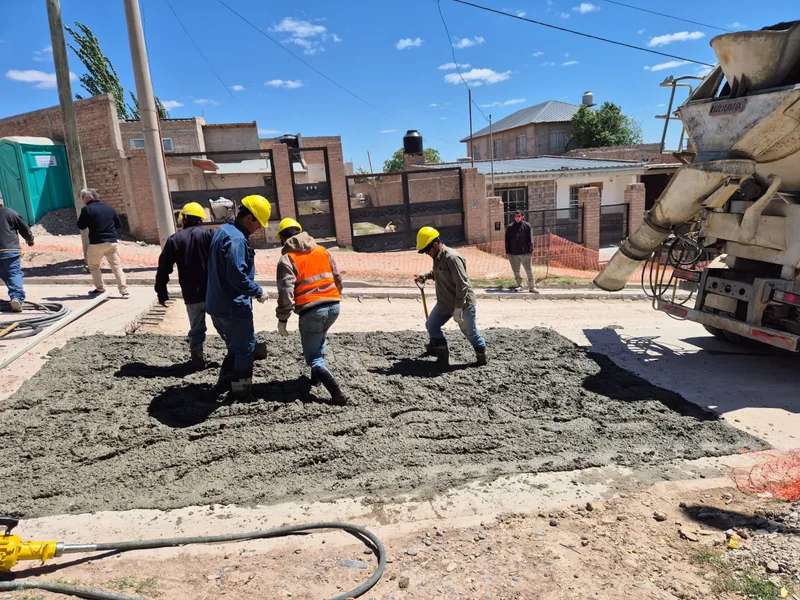 Cuadrilla de varios operarios terminando un tramo de hormigon en la calle