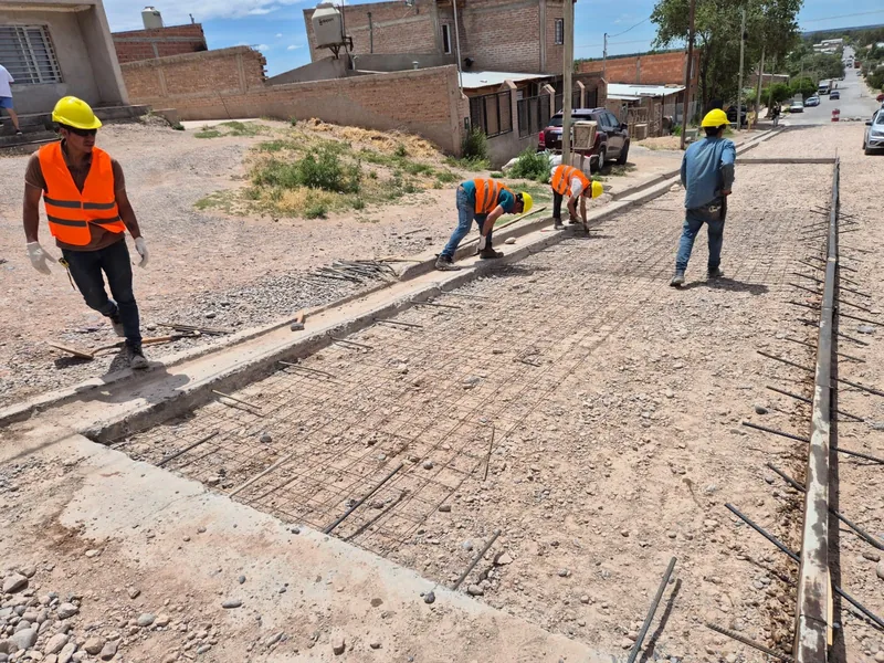 Operario terminando el hormigon de un cordon cuneta en un barrio