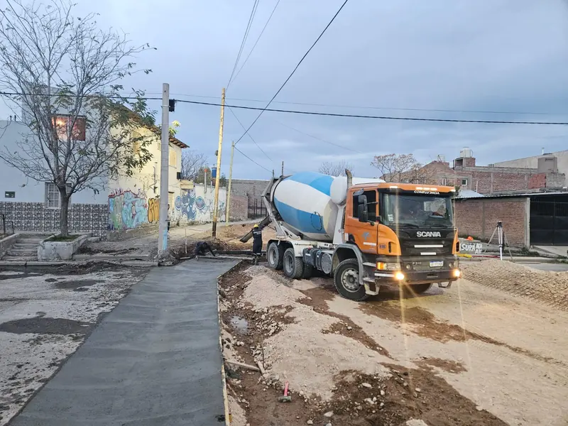 Concrete mixer truck on a residential street beside a newly laid concrete sidewalk