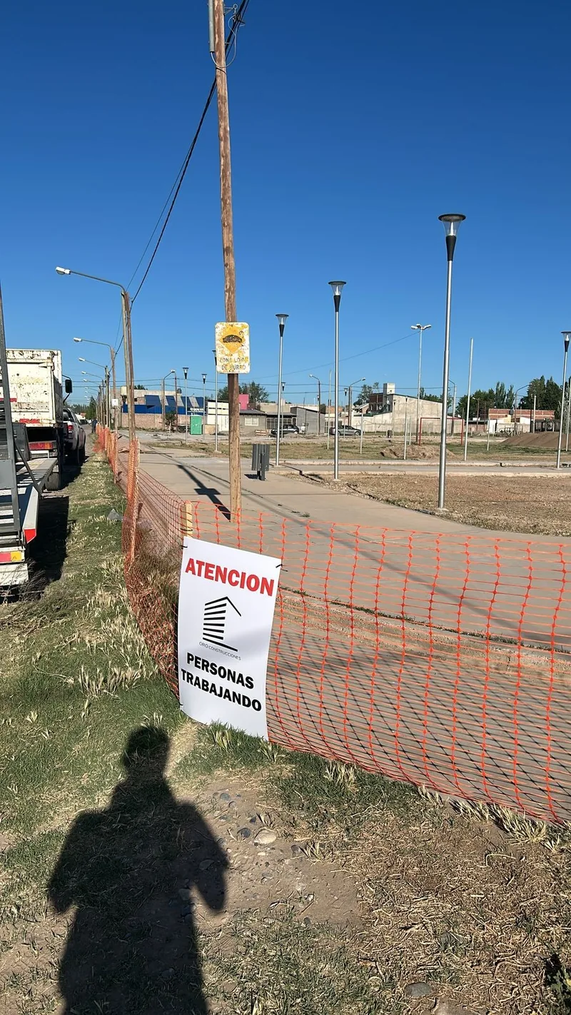 Operario junto al cartel de obra municipal en la vía publica