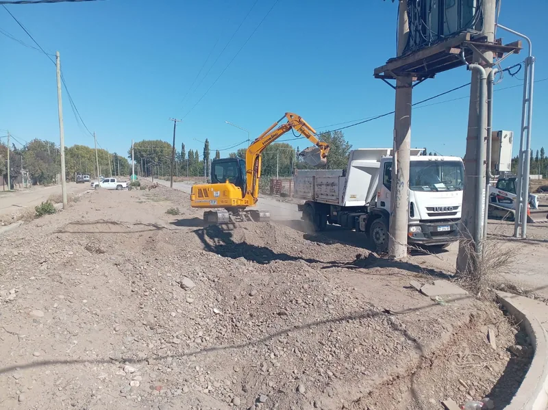 Retroexcavadora y camion trabajando en el bacheo de una calle