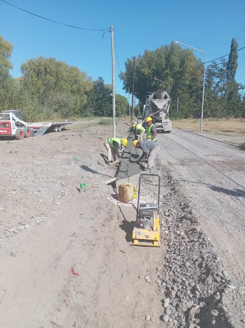 Cuadrilla de varios operarios terminando un tramo de hormigon en la calle
