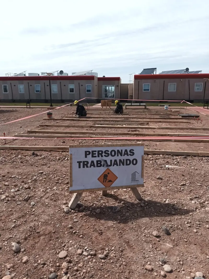 Men at work sign in front of the foundation setting out and the camp modules