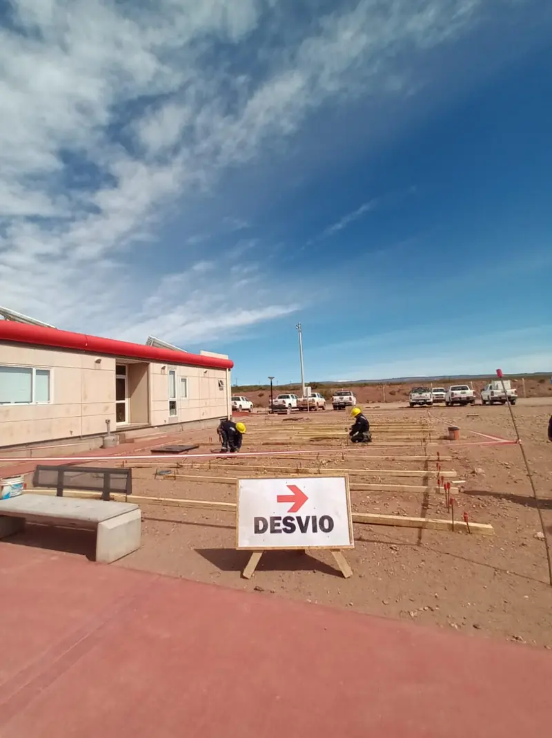 Diversion sign and workers alongside the concrete sidewalk of the building