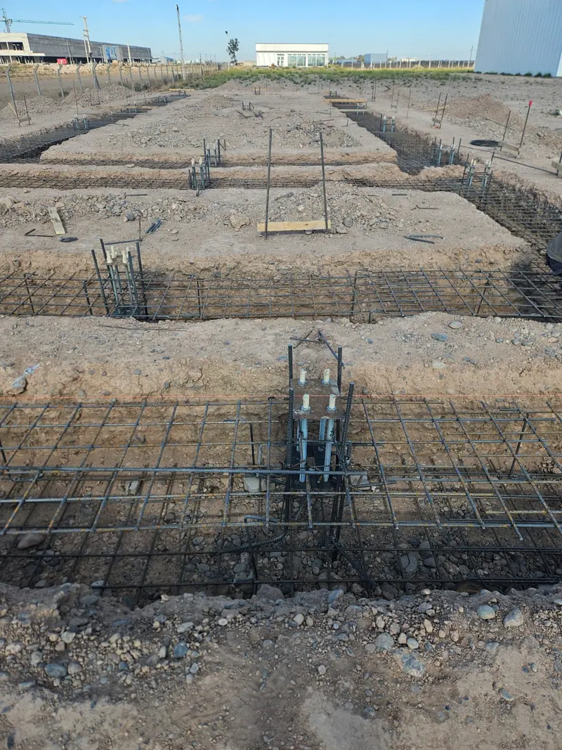 Fundaciones de hormigón armado con bases y vigas de hierro en obra industrial
