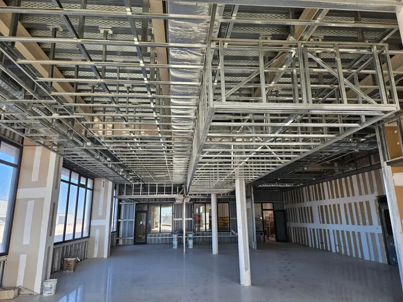 Interior with steel ceiling structure, glazing and concrete floor