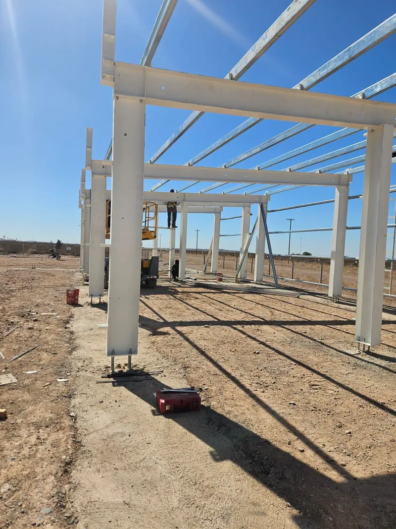 Montaje de estructura metálica de pórticos con plataforma elevadora y operario