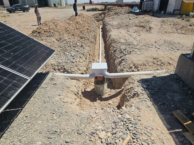 Zanja de instalaciones enterradas con cámara y cañerías junto a los paneles solares