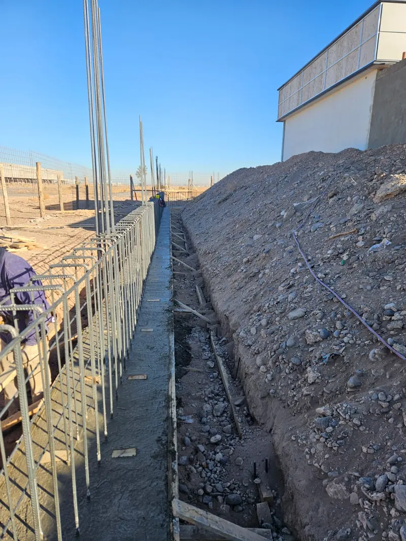 Viga de fundación hormigonada con armadura de espera junto al edificio