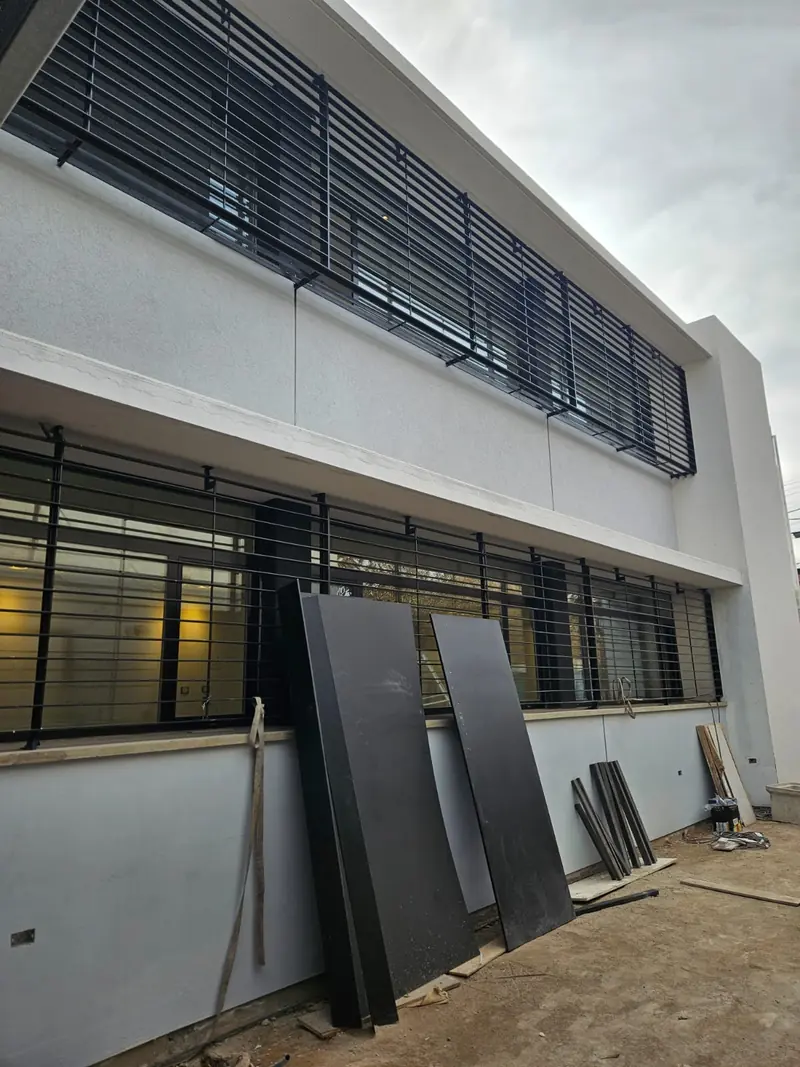 Black metal sun louvres over the facade windows at the final stage