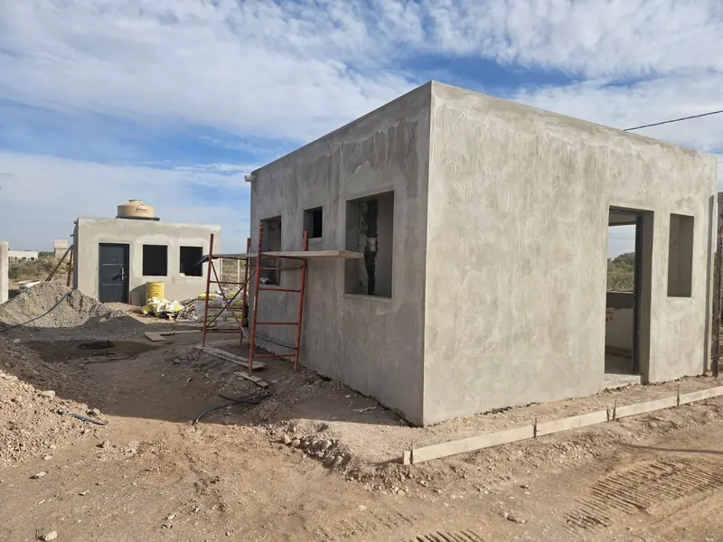 Obra en ejecución con muros revocados, andamio y cubierta plana ya ejecutada