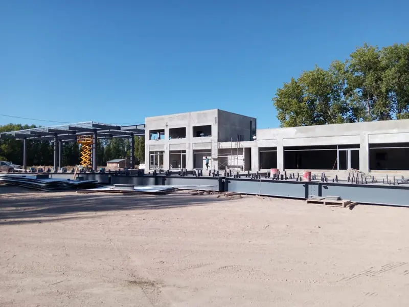 Obra en proceso con la estructura metálica de la playa y el volumen de hormigón del edificio principal