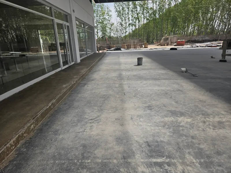 Vereda de hormigón junto al frente vidriado de la tienda durante las tareas de terminación