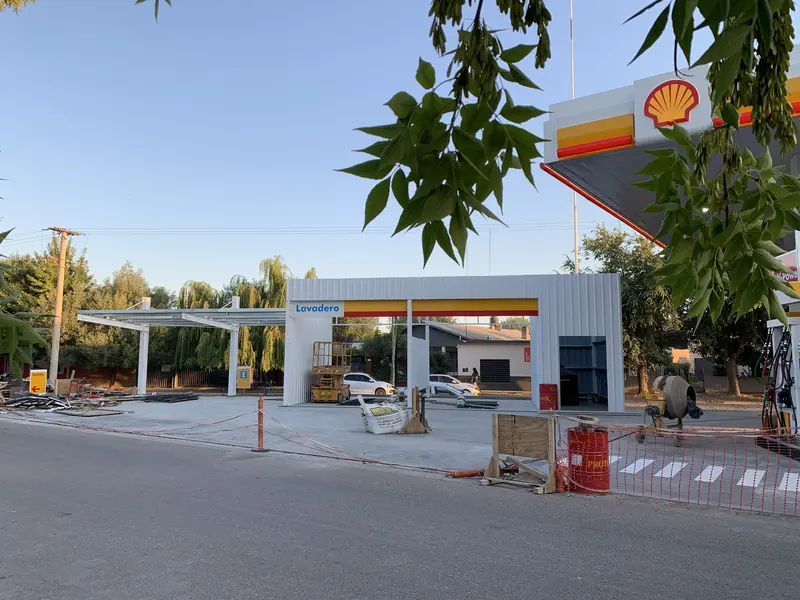 Vista lateral de la estación Shell con sector de lavadero y edificio de tienda