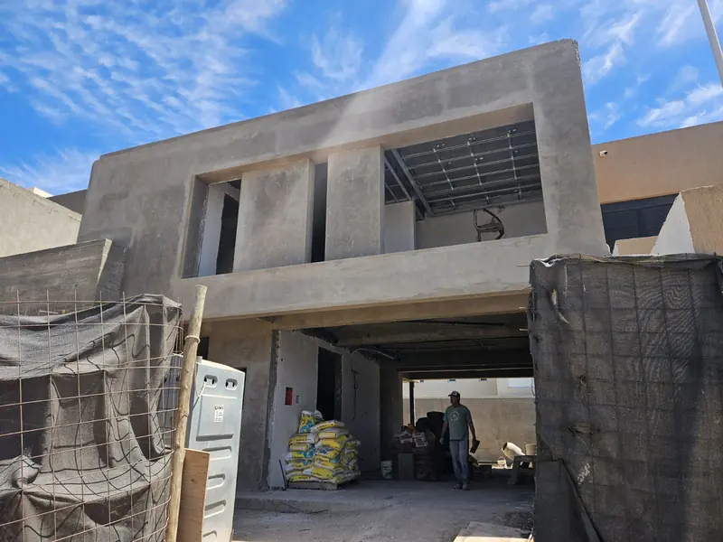 House at structural stage with exposed concrete and slab under construction