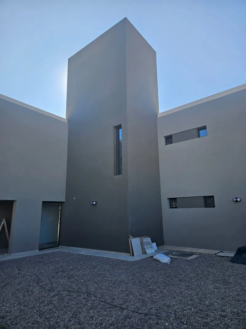 Internal courtyard with the rendered circulation block and a vertical window