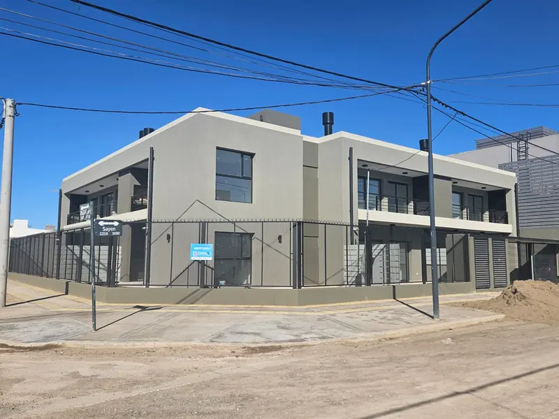 Corner of the completed two-storey residential building with balconies and metal railings