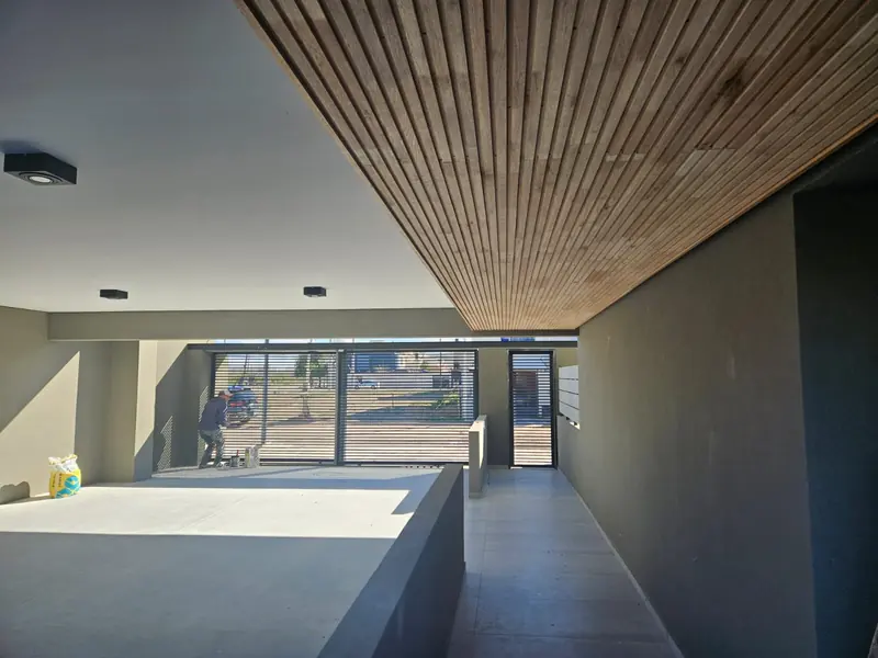 Completed interior with timber batten ceiling and full-height window to the front