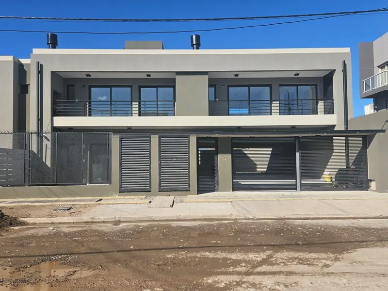 Front of the completed residential building with garages and balconies over the street