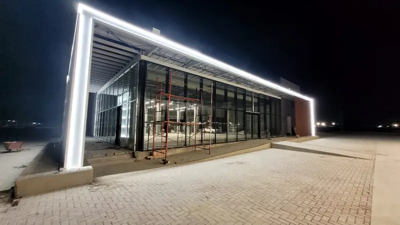 Glazed shopfront lit at night during interior finishing works