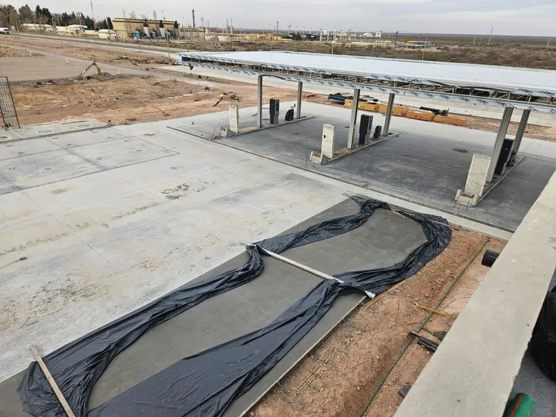 Pump islands under construction with the fresh concrete protected by plastic sheeting