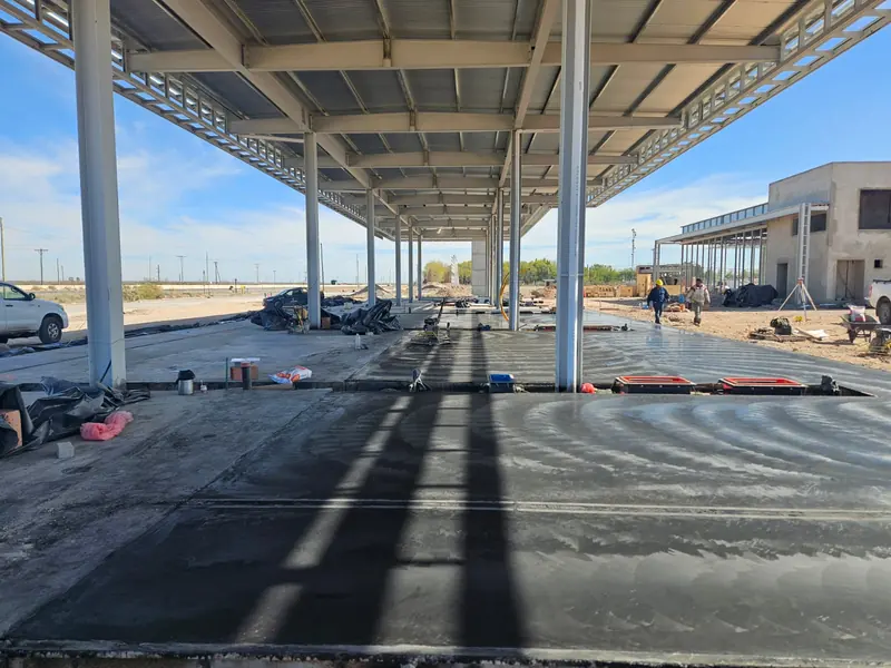 Fresh concrete slab covered with plastic sheeting under the canopy structure